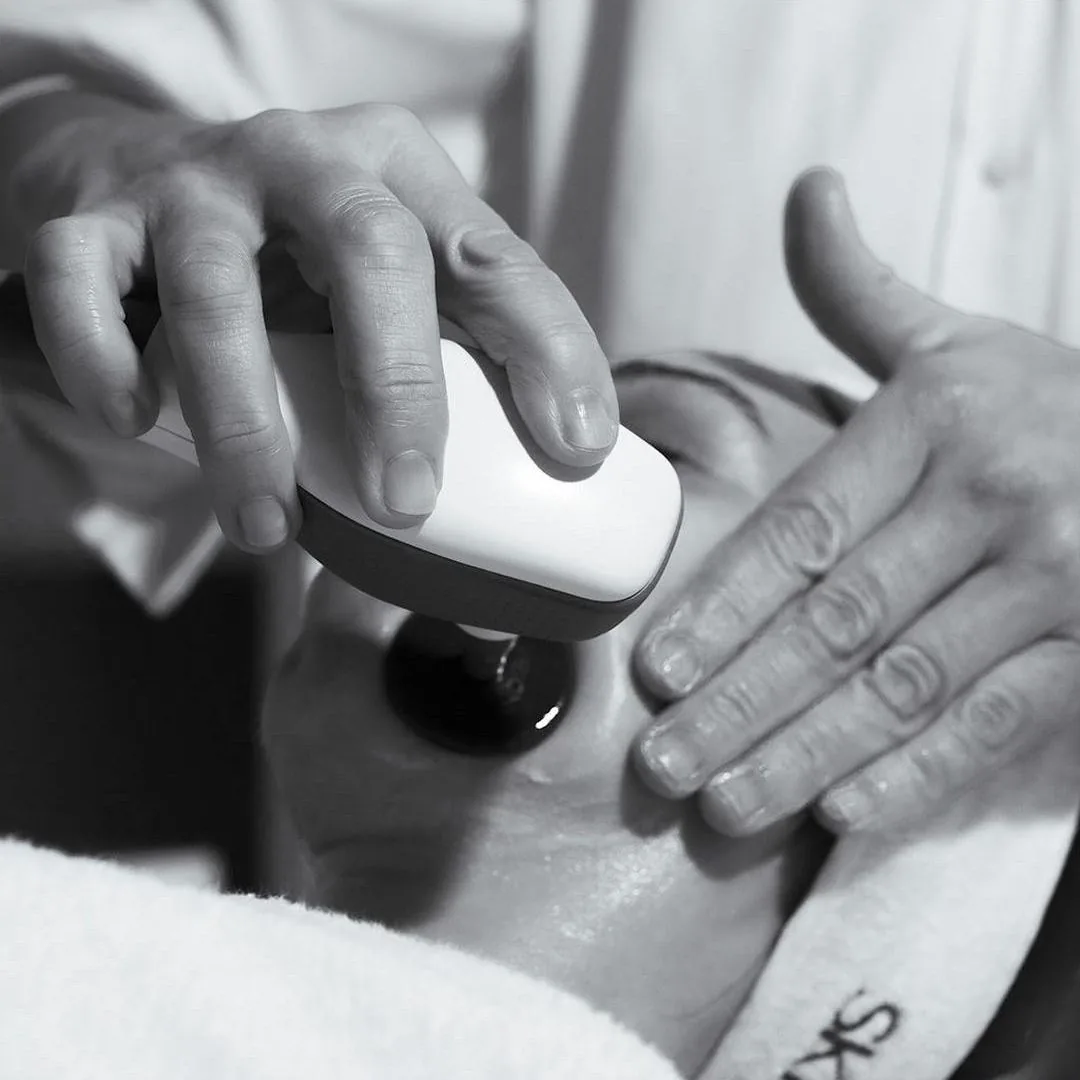 Manos de la esteticista aplicando un tratamiento facial con cosmética Skeyndor